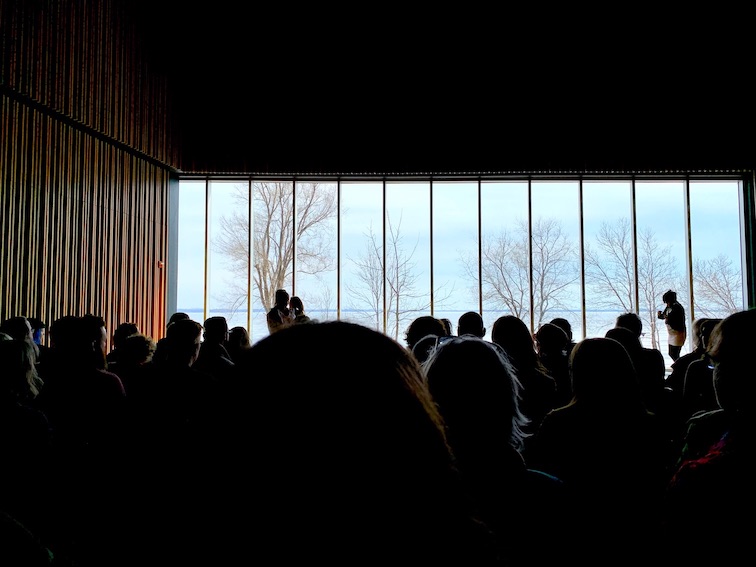 Image Caption: Audience watching Untitled by Tanya Lukin Linklater at Niigaani-Gichigami. Oniatarí:io, part of the Ka'tarohkwi Festival of Indigenous Arts at the Isabel Bader Centre for the Performing Arts.